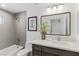 Well-lit bathroom with a tub, shower, vanity, and decorative mirror at 11775 Woodbrook Ct, Las Vegas, NV 89141