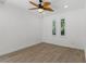 Bright bedroom with two arched windows, light wood-look floors, and modern ceiling fan at 11775 Woodbrook Ct, Las Vegas, NV 89141