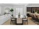Open-concept dining area featuring stylish chairs, wood table, and an open flow to the kitchen at 11775 Woodbrook Ct, Las Vegas, NV 89141