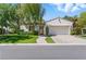 Charming single-story home with a manicured lawn, brick driveway, and lush, mature landscaping at 11775 Woodbrook Ct, Las Vegas, NV 89141