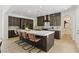 Modern kitchen featuring a large island with seating, stainless steel appliances, and dark wood cabinetry at 11775 Woodbrook Ct, Las Vegas, NV 89141