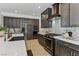Gourmet kitchen featuring stainless steel appliances, white countertops, dark cabinetry, and decorative backsplash at 11775 Woodbrook Ct, Las Vegas, NV 89141