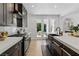 Modern kitchen with granite countertops, stainless steel appliances, and sleek dark cabinetry with backyard views at 11775 Woodbrook Ct, Las Vegas, NV 89141
