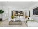Spacious living room with bright white walls, neutral furniture, and an open layout to the kitchen at 11775 Woodbrook Ct, Las Vegas, NV 89141