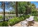 Outdoor patio area with comfortable seating and views of the lush green landscape and lake at 11775 Woodbrook Ct, Las Vegas, NV 89141