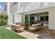 Outdoor patio with modern furniture and view to interior through large sliding glass doors to living room at 11775 Woodbrook Ct, Las Vegas, NV 89141
