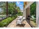 Inviting patio area with seating, overlooking a beautifully landscaped yard and serene lake at 11775 Woodbrook Ct, Las Vegas, NV 89141