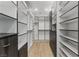 Spacious walk-in closet with ample shelving and wood flooring for organized storage at 11775 Woodbrook Ct, Las Vegas, NV 89141