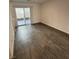 Bright living room with modern gray vinyl flooring and a sliding glass door at 12170 Midnight Pine Rd # 3, Las Vegas, NV 89183