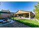 Backyard featuring artificial turf, covered patio, outdoor kitchen, fire pit, and pergola at 124 Strone St, Henderson, NV 89012