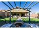 Backyard featuring artificial turf, covered patio with ceiling fan, fire pit, and outdoor seating at 124 Strone St, Henderson, NV 89012