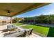 Relaxing backyard featuring a covered patio with outdoor seating and a lush lawn with a pergola at 124 Strone St, Henderson, NV 89012