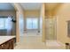 Bright bathroom featuring a soaking tub, tiled floors, and a separate glass-enclosed shower at 124 Strone St, Henderson, NV 89012