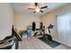 Neutral bedroom with ceiling fan and carpet, staging items include exercise bicycle and clothes rack at 124 Strone St, Henderson, NV 89012