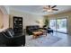 Comfortable living room with leather seating, a ceiling fan, and sliding glass doors to the backyard at 124 Strone St, Henderson, NV 89012