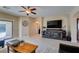 Bright living room with tile floors, large TV, and access to outdoor space through sliding glass door at 124 Strone St, Henderson, NV 89012