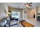 Cozy living room with sliding glass doors to the backyard, neutral decor, and a ceiling fan at 124 Strone St, Henderson, NV 89012