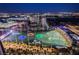 Nighttime view of a brightly lit Topgolf facility as seen from a high-rise balcony, overlooking the city at 135 E Harmon Ave # 2420, Las Vegas, NV 89109