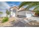Charming single-story home featuring desert landscaping, a two-car garage, and an arched entryway at 1512 Bellglen Dr, Las Vegas, NV 89128