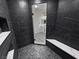 Nicely tiled shower with bench seating and glass door reveals view of bathroom with matching vanity at 1580 S Tiptop Trl, Pahrump, NV 89048