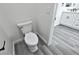 Bright bathroom features a toilet, vinyl plank flooring, and a view of the sink vanity at 1580 S Tiptop Trl, Pahrump, NV 89048