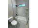 Modern bathroom featuring gray tile, white bathtub, and sleek black fixtures at 1580 S Tiptop Trl, Pahrump, NV 89048