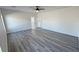 Spacious bedroom with gray vinyl floors, ceiling fan, and several doors at 1580 S Tiptop Trl, Pahrump, NV 89048