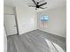 Bright bedroom features a plank floor, ceiling fan, double door closet, and view to the backyard at 1580 S Tiptop Trl, Pahrump, NV 89048
