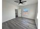 Bright bedroom with plank floors, ceiling fan, walk-in closet, and view of the backyard through the window at 1580 S Tiptop Trl, Pahrump, NV 89048