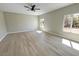 Bright bedroom with modern ceiling fan, light wood floors, and sun-filled windows at 1580 S Tiptop Trl, Pahrump, NV 89048