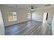 Bright bedroom with three windows and gray laminate flooring and ceiling fan at 1580 S Tiptop Trl, Pahrump, NV 89048