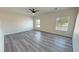 Spacious bedroom with two windows, ceiling fan and gray laminate flooring at 1580 S Tiptop Trl, Pahrump, NV 89048