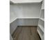 Organized walk-in closet with shelving and rods for efficient storage at 1580 S Tiptop Trl, Pahrump, NV 89048