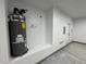 Water heater in a clean and organized garage corner next to the door and electrical installations at 1580 S Tiptop Trl, Pahrump, NV 89048