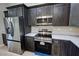 Modern kitchen featuring stainless steel appliances, dark wood cabinetry, and light countertops at 1580 S Tiptop Trl, Pahrump, NV 89048