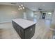 Open-concept kitchen includes an island, stainless appliances, light countertops, and wood cabinets at 1580 S Tiptop Trl, Pahrump, NV 89048
