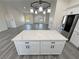 Kitchen island with marble countertop and white cabinets features overhead pendant lighting in open space at 1580 S Tiptop Trl, Pahrump, NV 89048