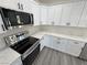 Modern kitchen features stainless steel appliances, white cabinets, marble countertops, and black hardware at 1580 S Tiptop Trl, Pahrump, NV 89048
