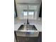Farmhouse stainless steel kitchen sink with modern faucet, quartz countertops, and a view overlooking the valley at 1580 S Tiptop Trl, Pahrump, NV 89048