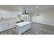 Bright kitchen features white cabinets, an island with marble countertops, and modern lighting at 1580 S Tiptop Trl, Pahrump, NV 89048