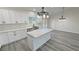 Open concept kitchen with marble countertops, white cabinets, pendant lighting and stainless steel appliances at 1580 S Tiptop Trl, Pahrump, NV 89048