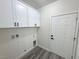Laundry room features white cabinets, hookups, and gray wood-look flooring at 1580 S Tiptop Trl, Pahrump, NV 89048