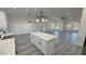 Open concept living room flows to modern kitchen featuring island with marble countertop, and pendant lighting at 1580 S Tiptop Trl, Pahrump, NV 89048