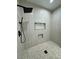 Contemporary shower featuring rainfall showerhead, niche storage, and patterned tile at 1580 S Tiptop Trl, Pahrump, NV 89048