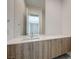 Modern bathroom featuring a floating vanity with wood grain cabinets and a large mirror at 1600 Pleasant Bay Ct, Henderson, NV 89011