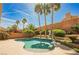 A backyard pool surrounded by palm trees and lush landscaping on a sunny day at 209 Camino Vista St, Henderson, NV 89012