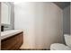Chic powder room featuring modern wood vanity, decorative accent wall, and contemporary fixtures at 209 Camino Vista St, Henderson, NV 89012