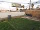 This backyard features a mix of faux grass and bare spots surrounded by wooden and chain link fences at 2409 Maroney Ave, Las Vegas, NV 89104
