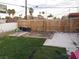 Backyard with a mix of faux grass and bare dirt, enclosed by wooden and chain link fences at 2409 Maroney Ave, Las Vegas, NV 89104