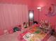 A whimsical pink bedroom with a race car bed and cute decor offers a playful and imaginative space at 2409 Maroney Ave, Las Vegas, NV 89104